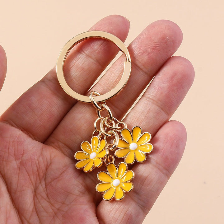 Women's white daisy flower enamel charm keychain for bags & keys. Cute floral accessory.