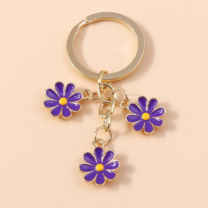 Women's daisy flower charm keychain. Cute enamel accessory for keys, bags, and purses.
