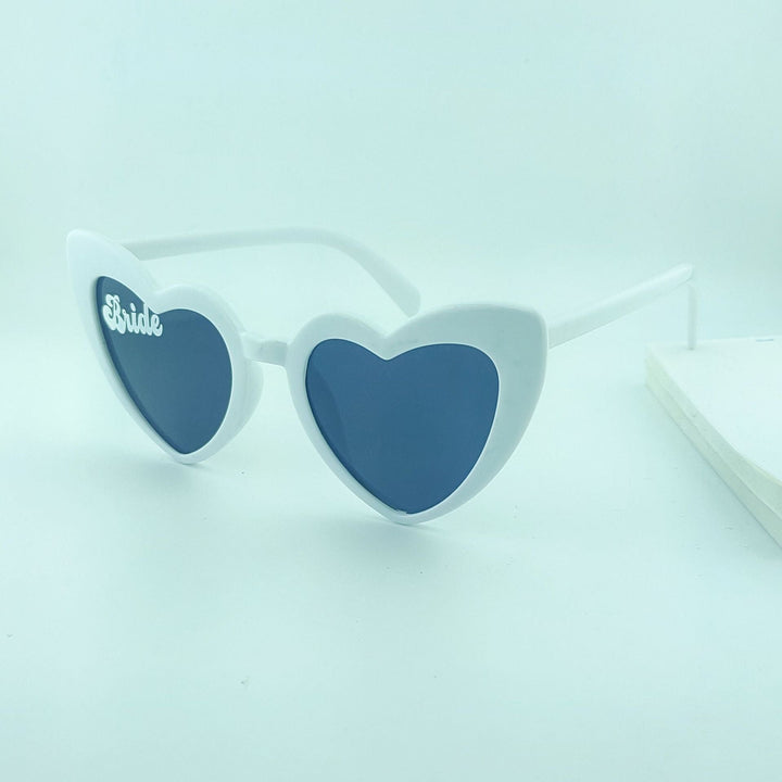 Close-up of women's heart-shaped pearl sunglasses, a glamorous touch for bridal events.