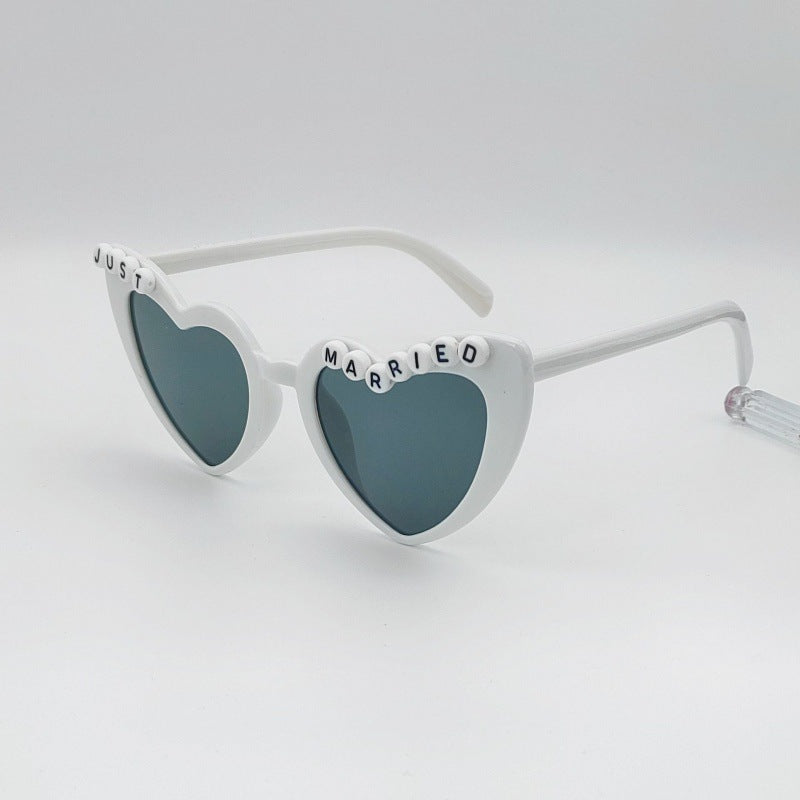 Chic women's heart bridal sunglasses, enhancing any bachelorette party or wedding photo.