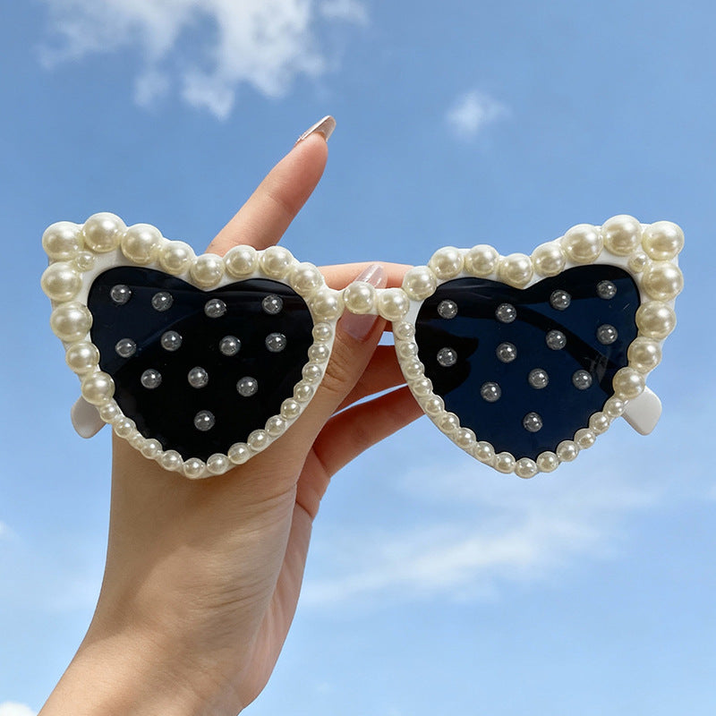 Women's white heart-shaped bridal sunglasses with elegant pearls. Perfect wedding accessory for the bride.
