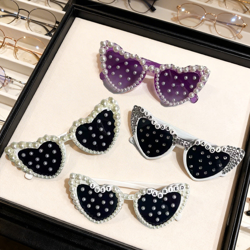 Unique heart sunglasses adorned with faux pearls, designed for a modern bride's wedding day look.