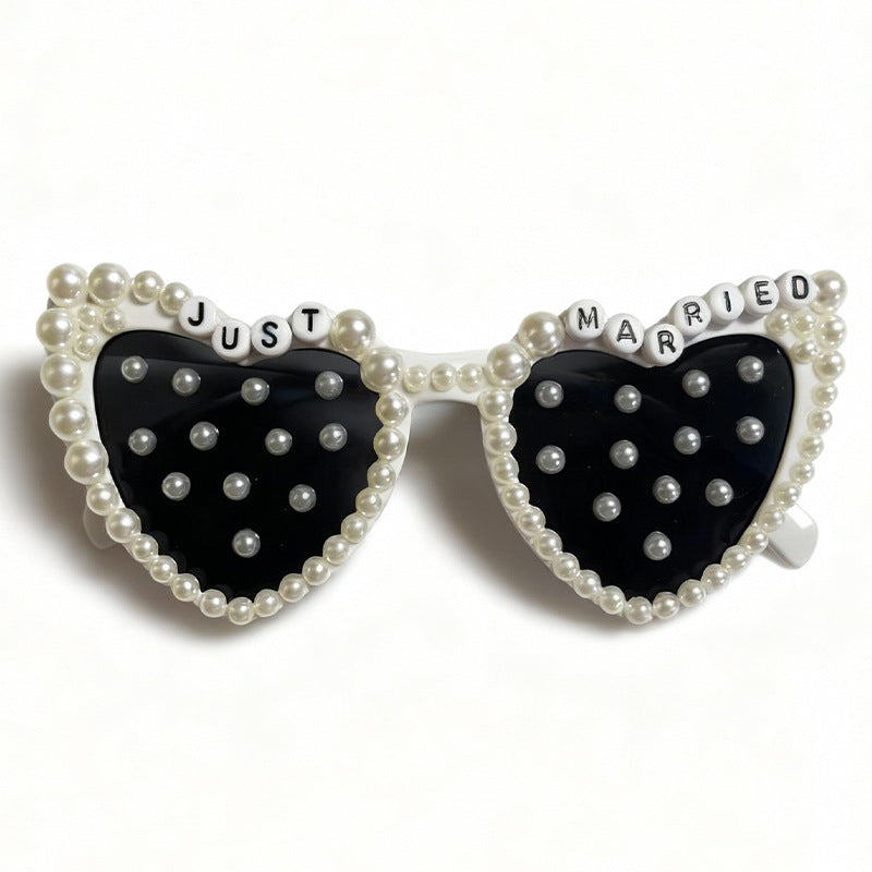 Elegant women's heart-shaped wedding sunglasses, embellished with beautiful pearls for a chic bridal accessory.