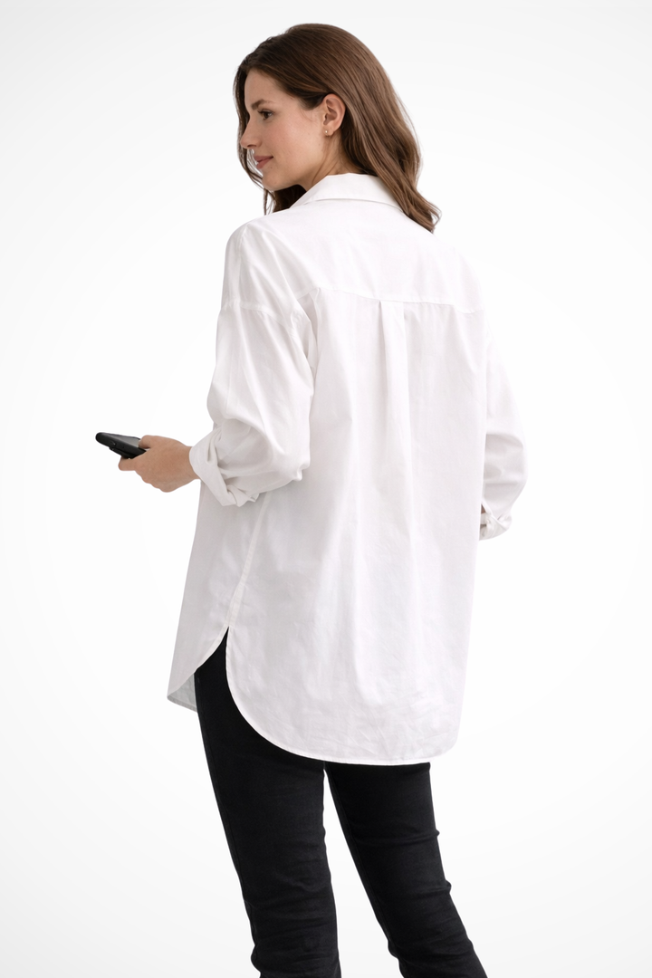 Crisp white women's long sleeve button down blouse. Oversized and relaxed fit, perfect for modern wear.