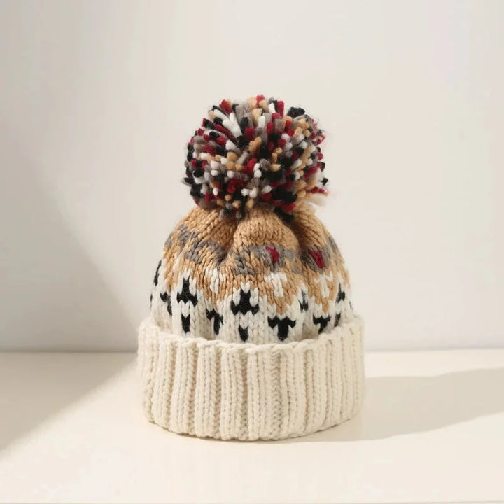 Warm women's pom-pom winter hat with a classic snowflake pattern and comfortable ribbed cuff for cold weather.