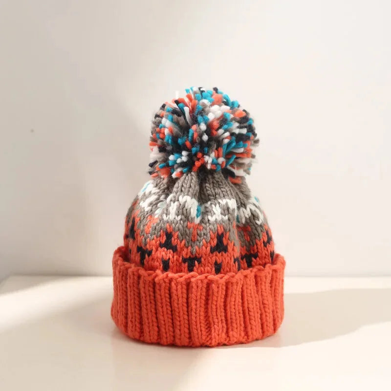Women's knit pom-pom beanie showcasing an intricate snowflake pattern and a snug ribbed cuff for warmth.
