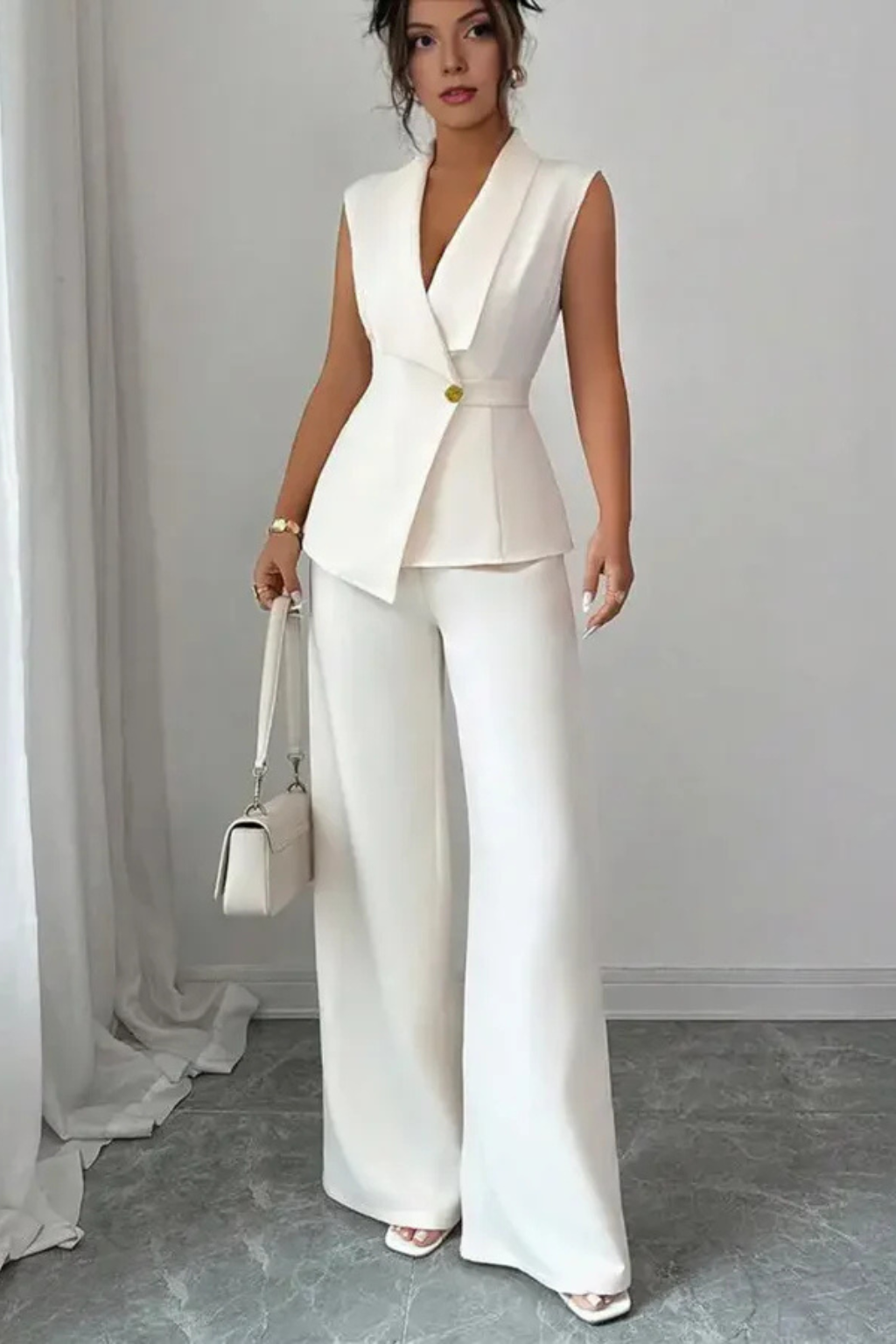 Crisp white tailored women's suit set, featuring a sleeveless blazer & elegant wide leg trousers. Stylish formal wear.