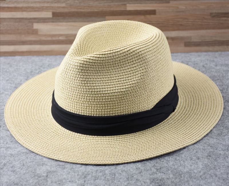 Stylish women's straw sun hat with a wide brim for maximum UV sun protection at the beach.