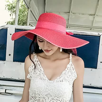 Fashionable women's wide brim straw hat with chic bow detail. A must-have summer accessory for beach.
