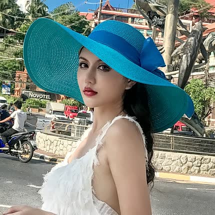 Classic women's wide brim straw sun hat with charming bow, offering UV protection for beach vacations.