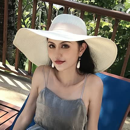 Chic women's wide brim straw sun hat, featuring a sophisticated bow. Perfect for sunny beach days & resort wear.