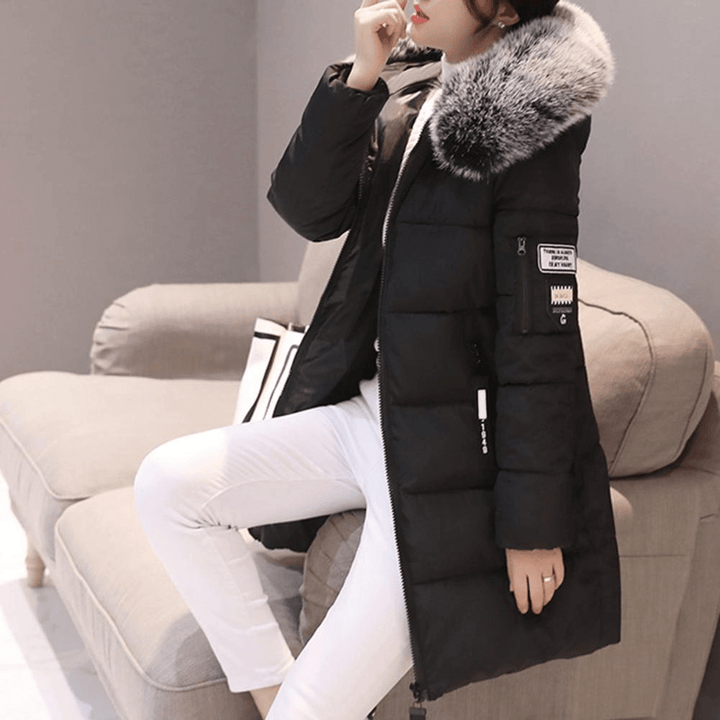 Side view of a woman wearing a black mid-length windproof puffer coat.