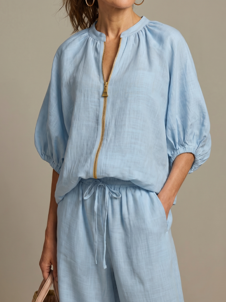 Stylish women's zip front blouson top paired with wide leg pants for a chic summer look.