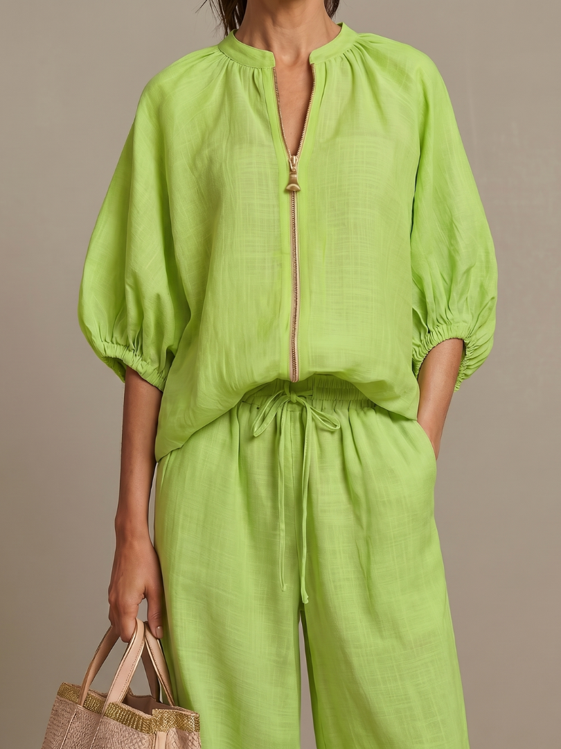 Two-piece women's set: Blouson top with zip detail and flowy wide leg pants. Casual fashion.